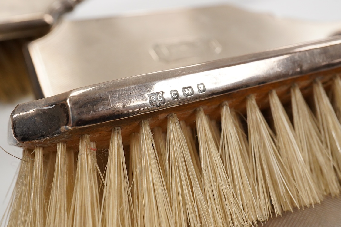 A 1930' matched engine turned silver mounted four piece dressing table brush set, William Comyns & Sons Ltd, London, 1933,36,38 & 39.